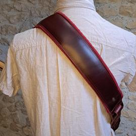 Ac­ces­soires pour Gui­tares & Basses 10/9 ème Musicwear - Sangle pour guitare/basse en cuir marron, rembourrée, doublée suédine rouge. - Sangles