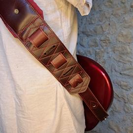 Ac­ces­soires pour Gui­tares & Basses 10/9 ème Musicwear - Sangle pour guitare/basse en cuir marron, rembourrée, doublée suédine rouge. - Sangles