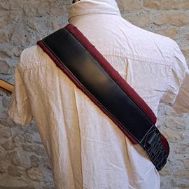 Ac­ces­soires pour Gui­tares & Basses 10/9 ème Musicwear - Sangle pour guitare/basse en cuir noir, rembourrée, doublée suédine rouge. - Sangles
