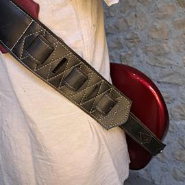 Ac­ces­soires pour Gui­tares & Basses 10/9 ème Musicwear - Sangle pour guitare/basse en cuir noir, rembourrée, doublée suédine rouge. - Sangles
